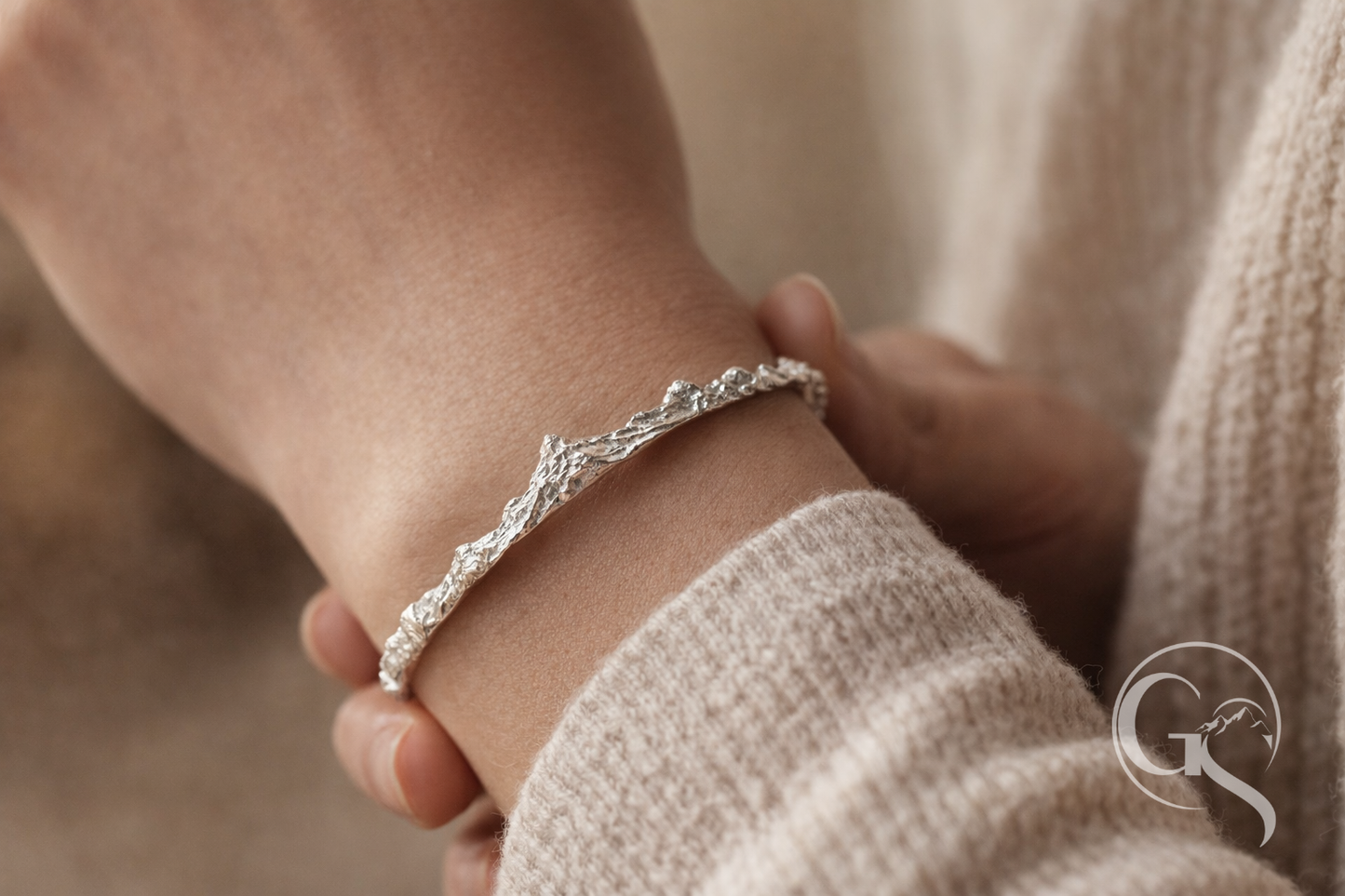 Detailansicht eines handgefertigten Armreifs aus 999 Silber mit alpiner Oberflächenstruktur