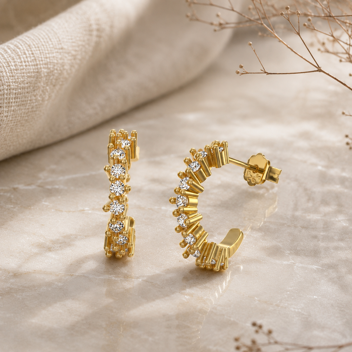 Celestia Ohrringe in Gold mit geschwungenem Creolen-Design und mehreren funkelnden Steinen